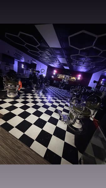 Salt City Barber Shop at night with the chairs lit in purple